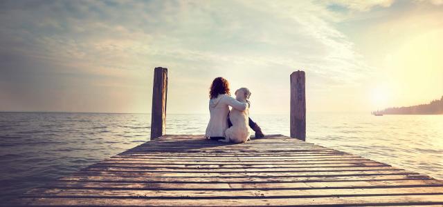 Woman Embracing Her Dog While Looking the View